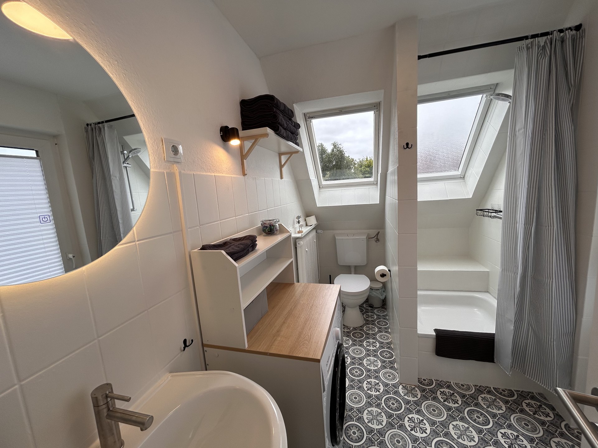 Badezimmer mit Dusche und Waschmaschine in Ferienwohnung 4