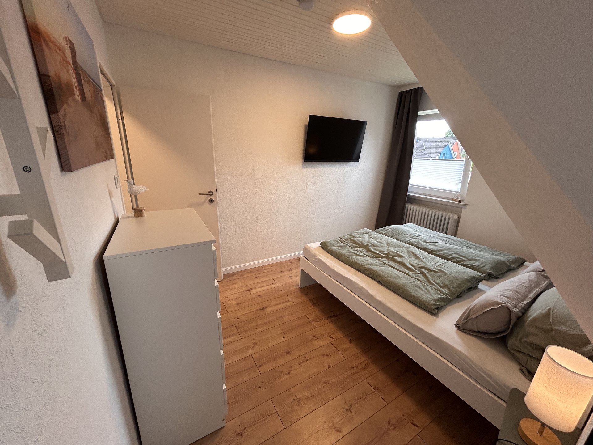 Schlafzimmer mit 180 Zentimeter breitem Doppelbett und Smart-TV